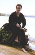 picture of Jeff Herge seated on a stump at the beach