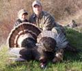 Photo of father and son with harvested wild turkeys.