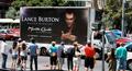 A 'Lance Burton at the Monte Carlo' advertisement on a mobile billboard passes by a crowd of onlookers.