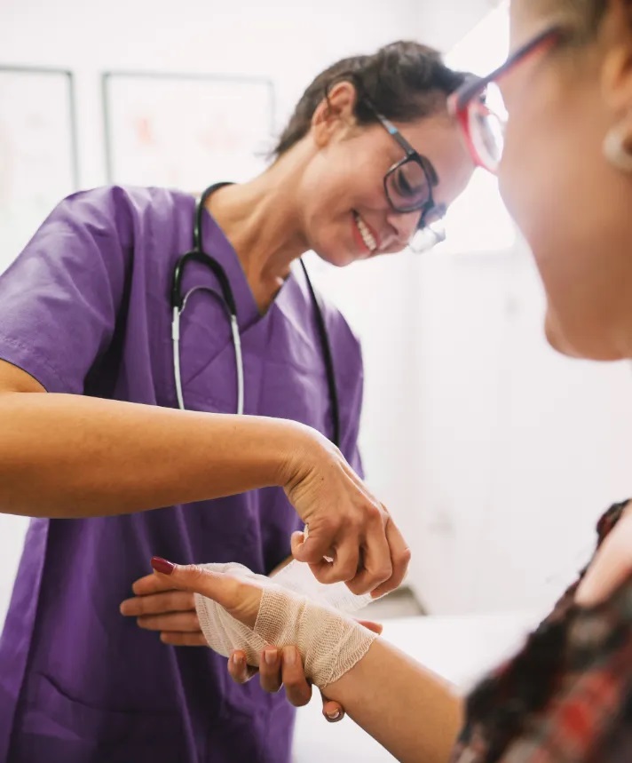 A healthcare professional wraps the hand of a patient