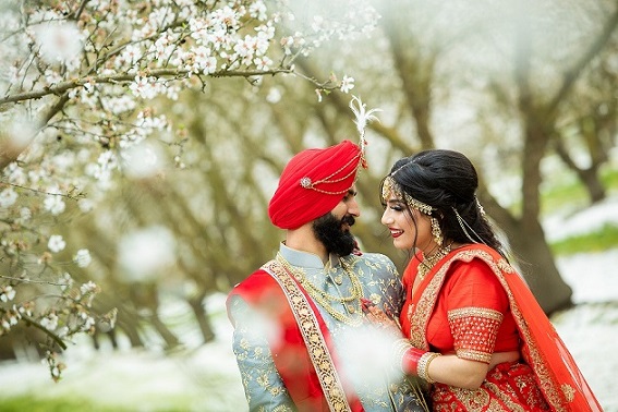 Sikh wedding couple in field of white flowers